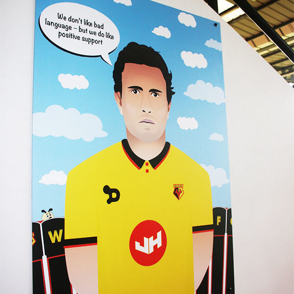 An image illustration print of Daryl Janmaat, displayed in the Family Stand at Vicarage Road Stadium.